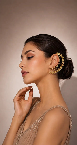 Woman wearing a gold shell-fan ear cuff by Ornamint